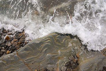 Image showing The wave rolls on a rocky shore, aerial view