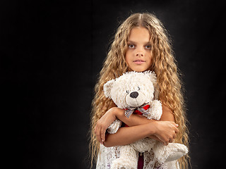 Image showing Portrait of a teenage girl who hugs an old soft toy bear