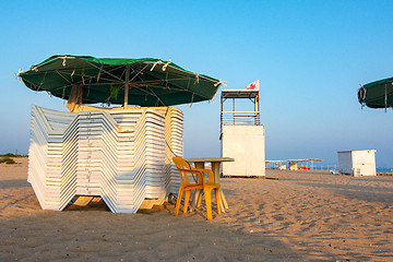 Image showing Folded sun loungers and an empty lifeguard post on a deserted sandy beach