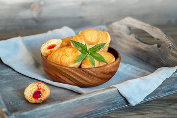 Image showing Croissants on a wooden tray. The concept of a wholesome breakfast.