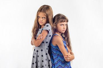 Image showing Two offended girls stand with their backs to each other