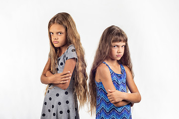 Image showing Two offended girls stand with their backs to each other