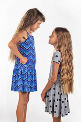 Image showing Two girls of different stature, one of them stood on a chair to be taller than the other