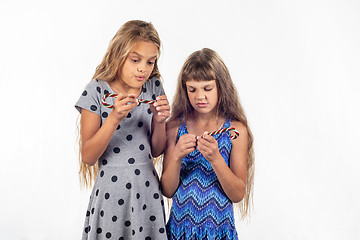 Image showing Two girls can not open the plastic packaging of caramel candies