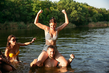 Image showing Happy group of friends having fun, laughting and swimming in river