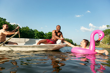 Image showing Happy group of friends having fun, laughting and swimming in river