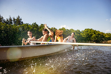 Image showing Happy group of friends having fun, laughting and swimming in river