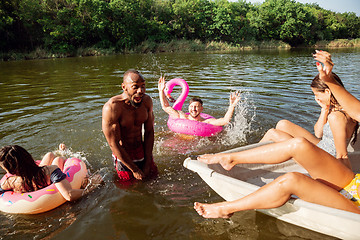 Image showing Happy group of friends having fun, laughting and swimming in river