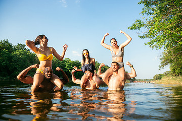 Image showing Happy group of friends having fun, laughting and swimming in river