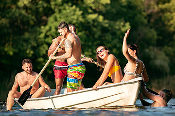 Image showing Happy group of friends having fun, laughting and swimming in river