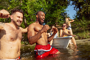 Image showing Happy group of friends having fun, laughting and swimming in river