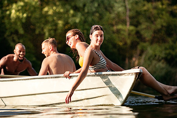 Image showing Happy group of friends having fun, laughting and swimming in river