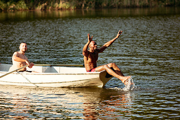 Image showing Happy group of friends having fun, laughting and swimming in river