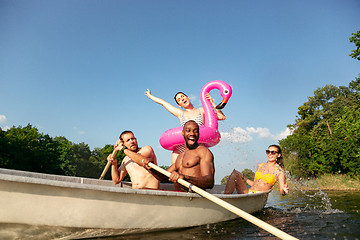 Image showing Happy group of friends having fun, laughting and swimming in river