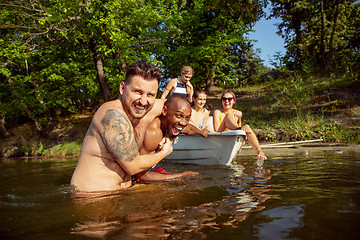 Image showing Happy group of friends having fun, laughting and swimming in river