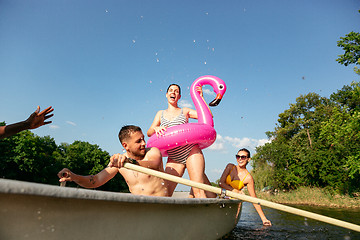 Image showing Happy group of friends having fun, laughting and swimming in river