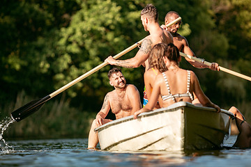 Image showing Happy group of friends having fun, laughting and swimming in river