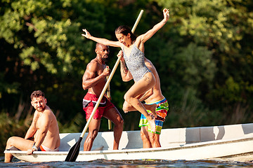 Image showing Happy group of friends having fun, laughting and swimming in river