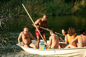 Image showing Happy group of friends having fun, laughting and swimming in river