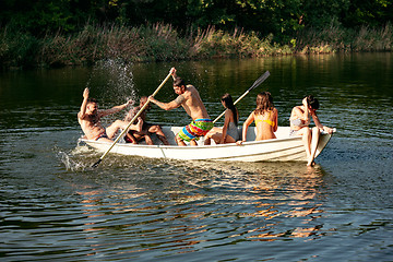 Image showing Happy group of friends having fun, laughting and swimming in river