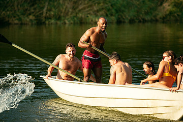 Image showing Happy group of friends having fun, laughting and swimming in river