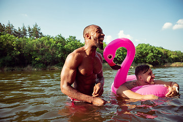 Image showing Happy group of friends having fun, laughting and swimming in river