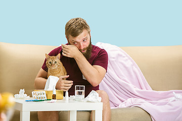 Image showing Young man suffering from allergy to cat hair