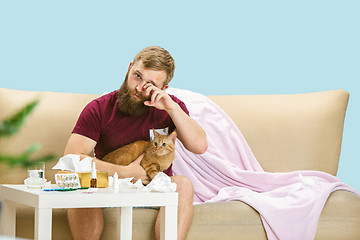 Image showing Young man suffering from allergy to cat hair