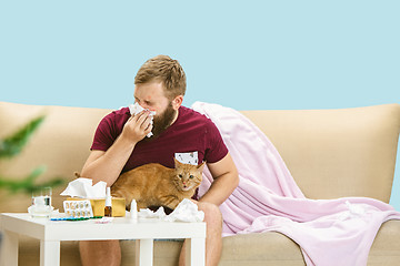 Image showing Young man suffering from allergy to cat hair