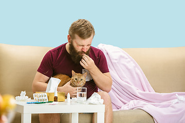Image showing Young man suffering from allergy to cat hair