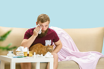 Image showing Young man suffering from allergy to cat hair