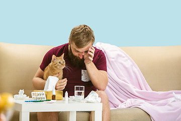 Image showing Young man suffering from allergy to cat hair