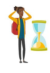 Image showing Worried african traveler man looking at hourglass.