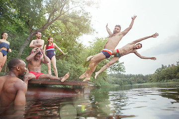 Image showing Enjoying river party with friends. Group of beautiful happy young people at the river together