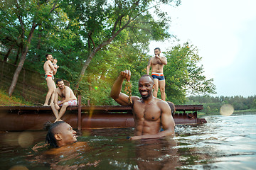 Image showing Enjoying river party with friends. Group of beautiful happy young people at the river together