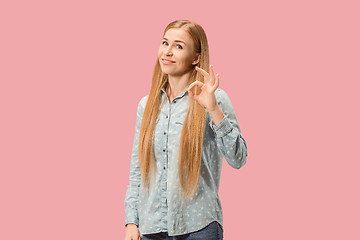 Image showing The happy business woman standing and smiling against pink background.