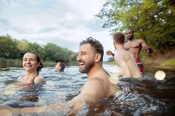 Image showing Enjoying river party with friends. Group of beautiful happy young people at the river together