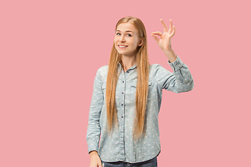 Image showing The happy business woman standing and smiling against pink background.