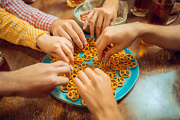 Image showing people, leisure, friendship and communication concept - happy friends drinking beer, talking and clinking glasses at bar or pub