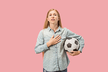 Image showing Fan sport woman player holding soccer ball isolated on pink background