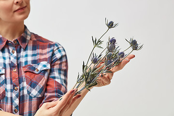 Image showing Young girl with flowers eryngium