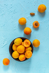 Image showing Ripe apricots in a black wooden bowl.