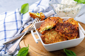 Image showing Zucchini fritters with sour cream sauce.