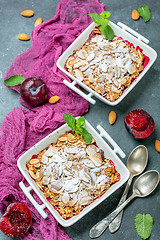 Image showing Crumble with red plums and oat flakes.