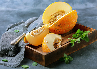 Image showing Slices of ripe yellow melon in a wooden tray.