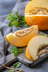 Image showing Slices of ripe yellow melon on a wooden board.