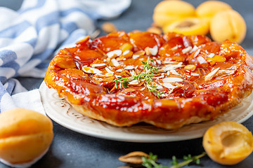 Image showing Apricot and almond tarte tatin on a white plate.