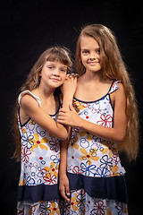 Image showing Two sisters of different ages on a black background