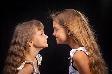 Image showing Two girls look at each other face to face