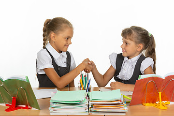Image showing Two girls at a desk shake hands